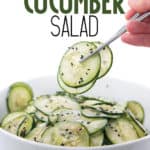 white bowl of cucumber slices with chopsticks holding cucumbers with title