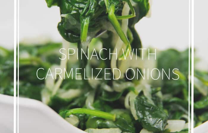white bowl of sauteed spinach with caramelized onions with a fork with some on it
