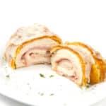 white plate of cut down the middle cordon bleu with ham and cheese inside chicken breast