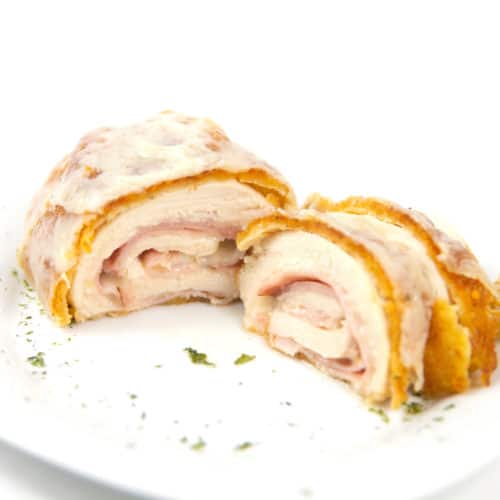 white plate of cut down the middle cordon bleu with ham and cheese inside chicken breast