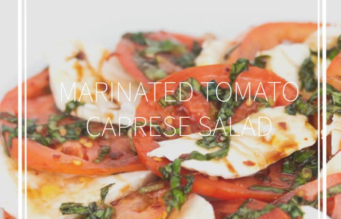 white plate of sliced tomatoes and mozzarella cheese with chopped basil and balsamic glaze on top