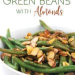 a white bowl of cooked balsamic green beans with almonds on top