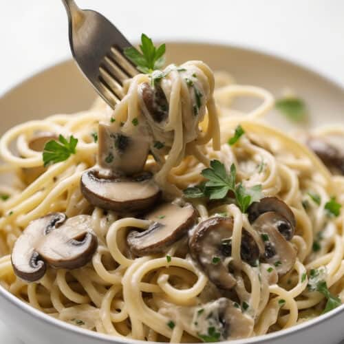 a bowl of Creamy Mushroom Pasta with a fork with pasta on it
