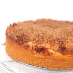 an apple cinnamon crumb cake sitting on a glass plate