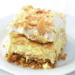 a slice of banana pudding pie with vanilla wafer on top on a white plate