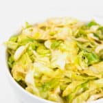 a white bowl of cajun fried cabbage