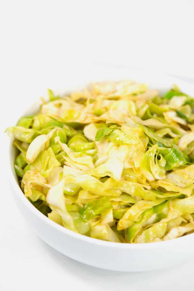 a white bowl of cajun fried cabbage