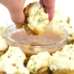 white plate with stuffing potato bbites with one dipping in gravy