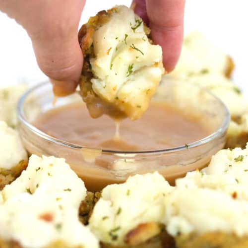 white plate with stuffing potato bbites with one dipping in gravy