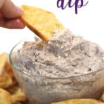 a glass bowl of whipped cheese with olives and artichokes and toasted bread dipping