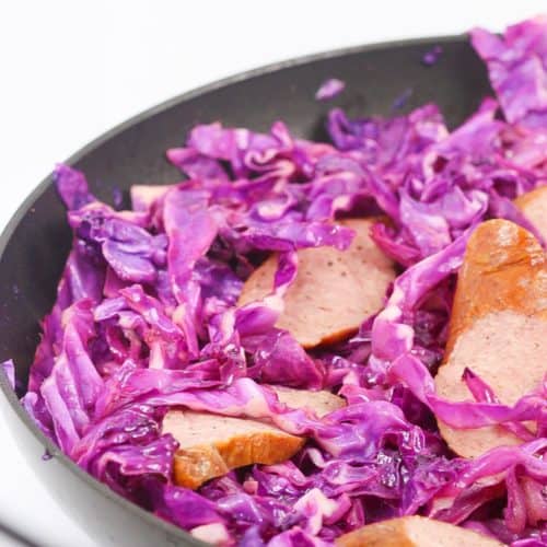 a side view of sausage and red cabbage in a pan