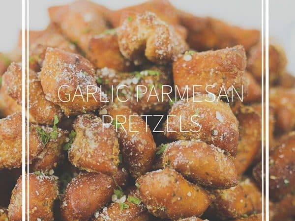 a white bowl of garlic parmesan pretzel nuggets with parmesan sprinkled on top