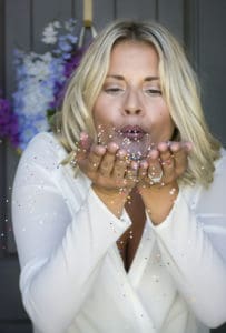 a picture of dainya from glitter and garze blowing sprinkles