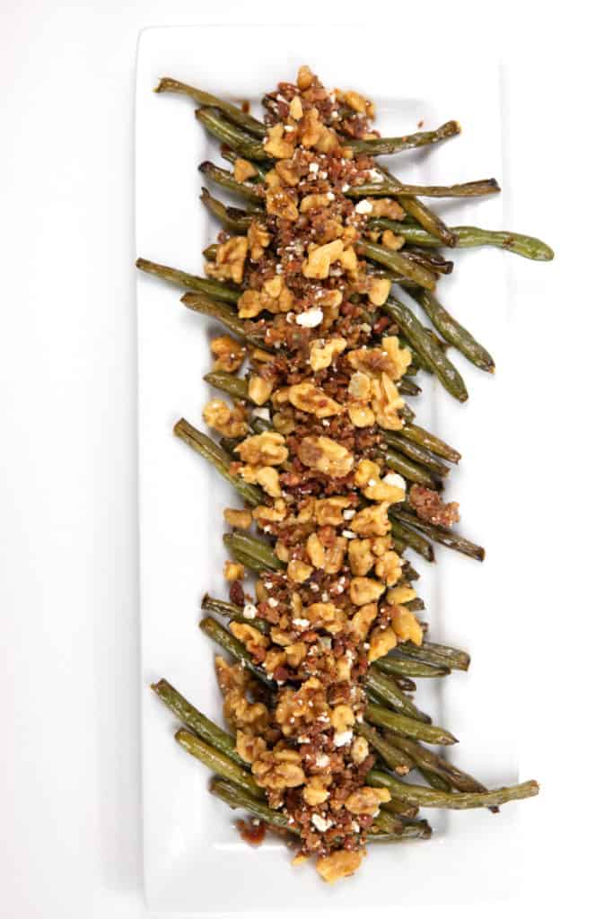 Green Beans with Bacon, Blue Cheese, and Walnuts overhead shot on a white rectangle plate