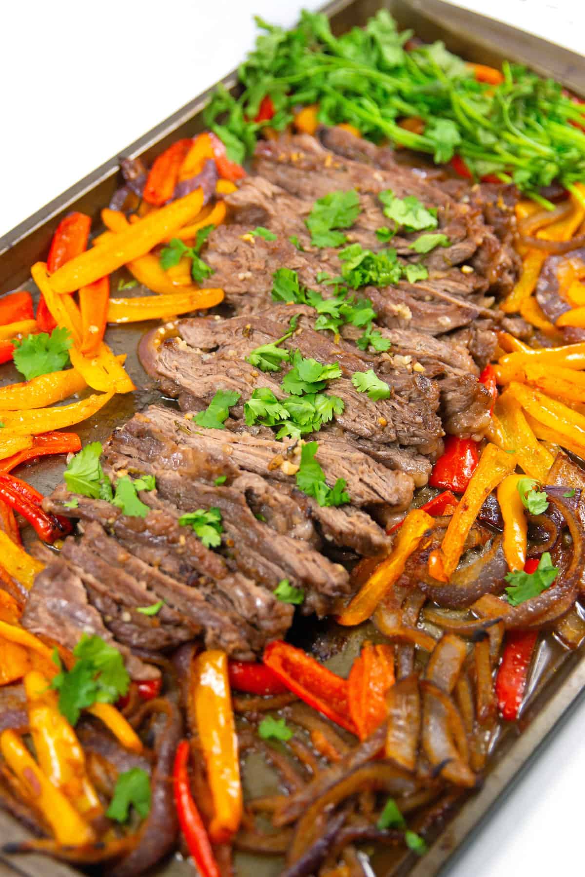 pan of sliced cilantro lime sheet pan fajitas with cilantro