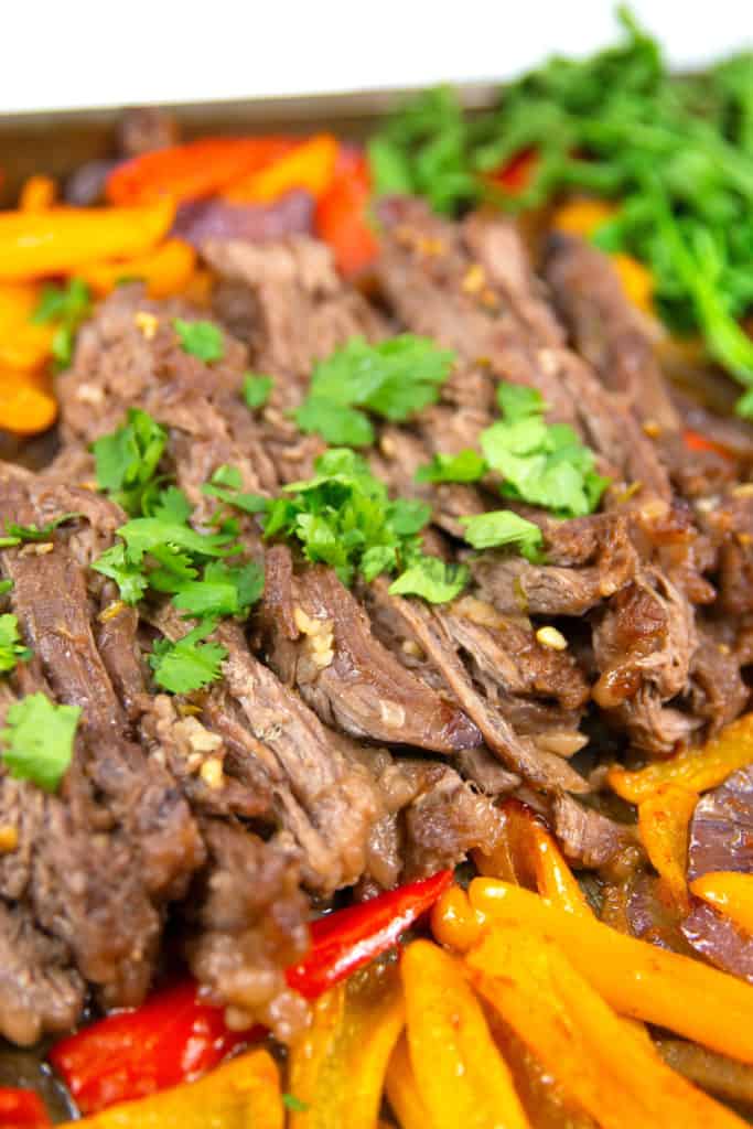 up close shot of cilantro lime sheet pan fajitas with cilantro on top