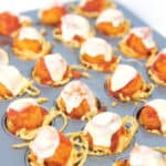mini muffin tin of cooked spaghetti cups with popcorn chicken parmesan