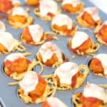 mini muffin tin of cooked spaghetti cups with popcorn chicken parmesan