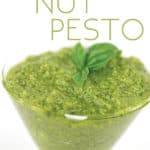 glass cup with pine nut pesto with basil leaves on top