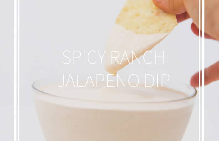 glass bowl of dip with a tortilla chip dipping into it