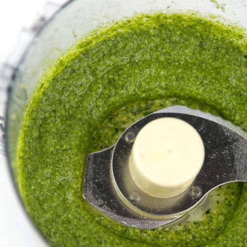 food processor bowl with green basil pine nut pesto