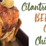 roasting pan with cooked whole chicken on a beer can with limes and cilantro