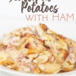 plate of creamy scalloped potatoes with ham with sliced potatoes, ham and a cheese sauce
