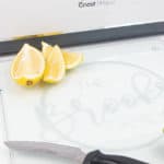 A cricut etched glass cutting board with limes, lemons and a knife