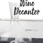 etched glass wine decanter with a cricut maker behind it