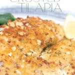 white and blue plate with almond crusted tilapia with a lemon slice and spinach