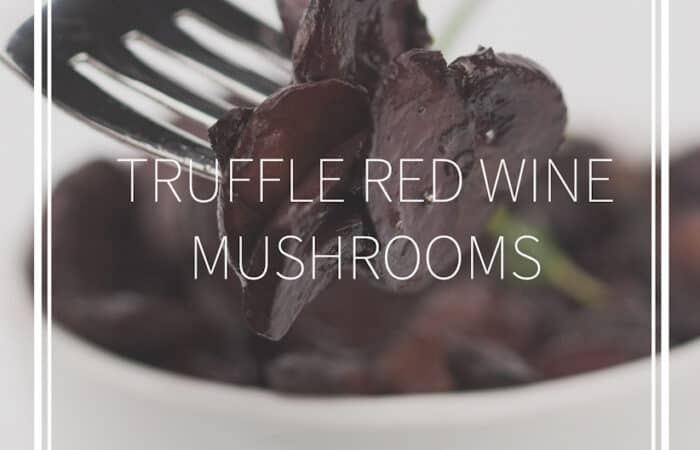 white bowl of sautéed truffle red wine mushrooms and a fork with the mushrooms on it