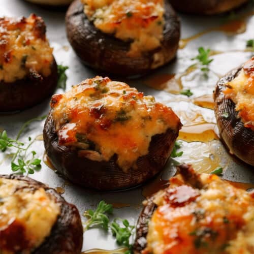 a crab and cheese stuffed mushroom with balsamic glaze on a pan