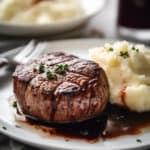 a cooked filet steak with mashed potatoes on a platw