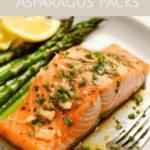 a salmon filet on a plate with a butter sauce and garlic and herbs with asparagus