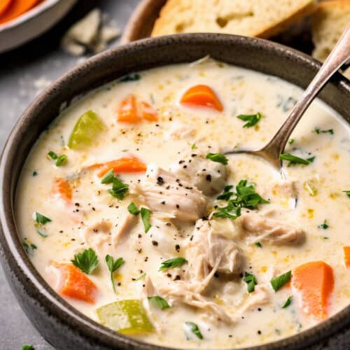 a bowl of Best-Ever Creamy Chicken Soup with carrots, celery and green garnish