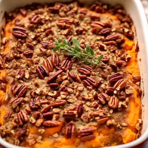 a casserole dish of Crunchy Pecan Sweet Potato Bake with pecan crumble on top