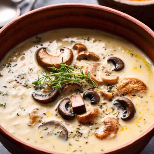 a bowl of creamy Creamy Forest Rice Soup with mushrooms and green herbs on top